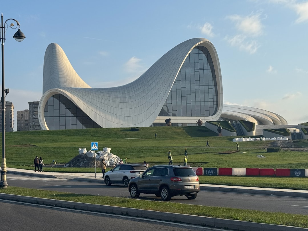 modern-white-building-with-curved-architecture-on-grassy-hill-xndn2ilfs6c